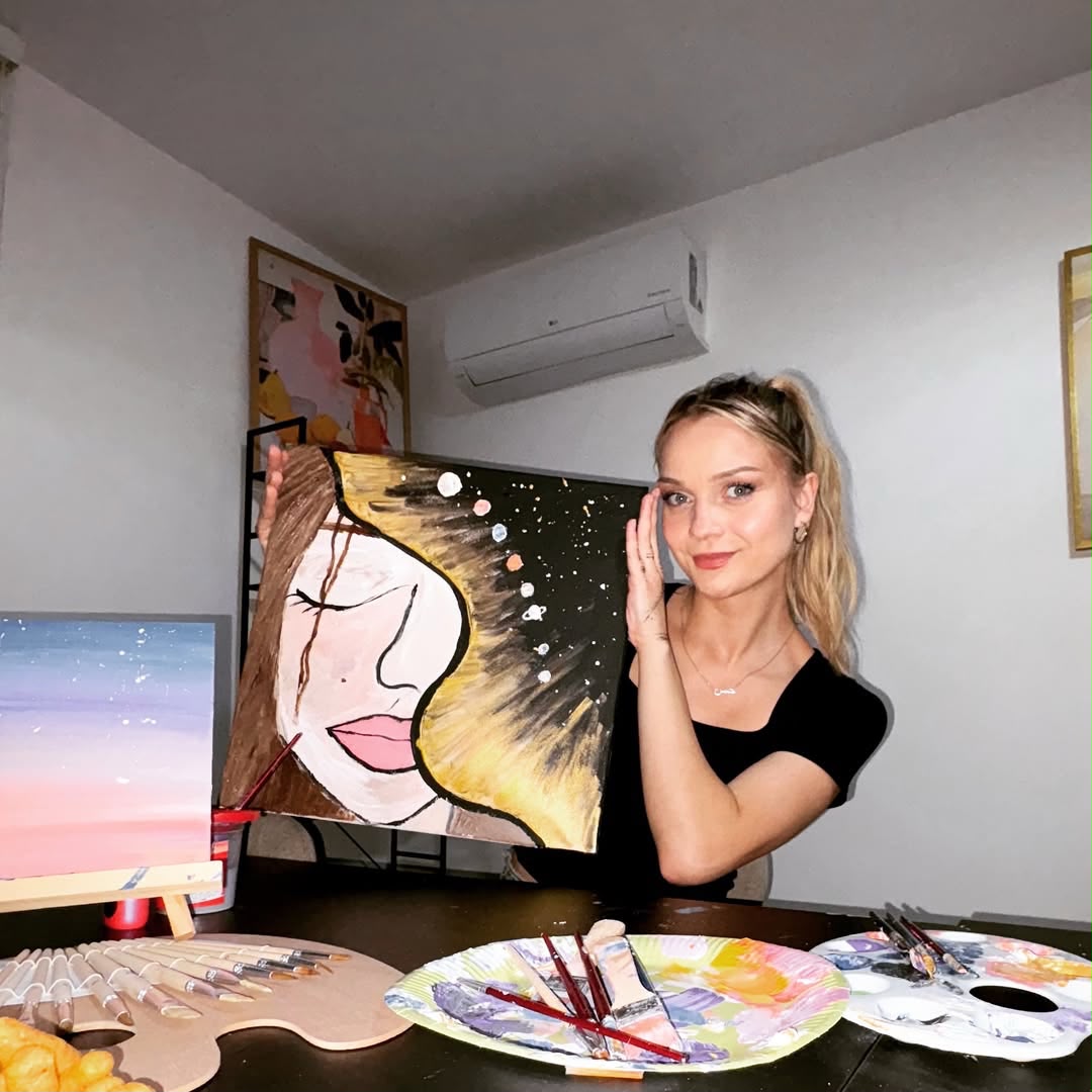 Umjetnica drži ručno oslikano platno u studiju